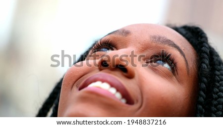 African woman looking up to sky feeling freedom and happiness, Black girl closeup face