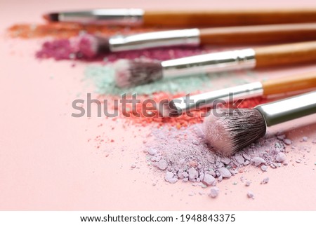 Different makeup brushes with crushed cosmetic products on pink background, closeup. Space for text