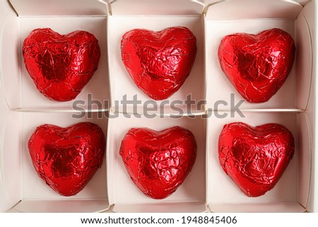 Tasty heart shaped chocolate candies in box, top view. Valentine's day celebration