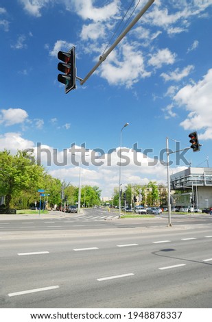Highway, crossroad, pedestrian walkway, street lights in a city. Cars and buildings. Traffic code, safety, control, communications, infrastructure, tourism, road trip, vacations. Summer cityscape