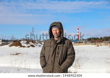 Man in the background of the village winter landscape