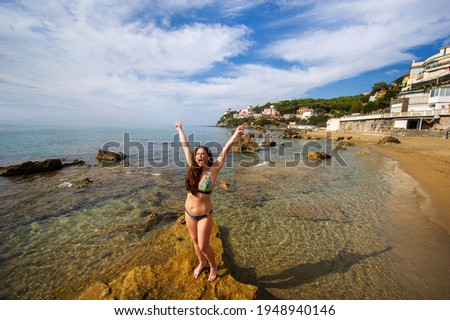 A girl in a swimsuit on the beach in Castiglioncello. Italy, Tuscany.