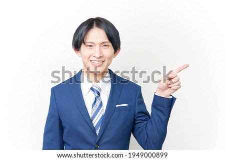 Asian businessman pointing side on white