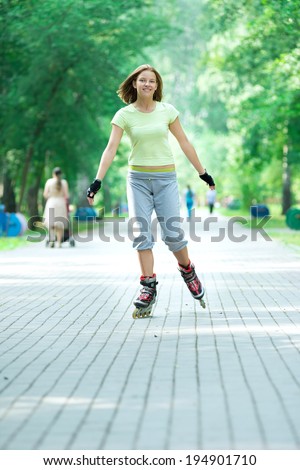 Roller skating sporty girl in park rollerblading on inline skates.  Caucasian woman in outdoor fitness activities. 
