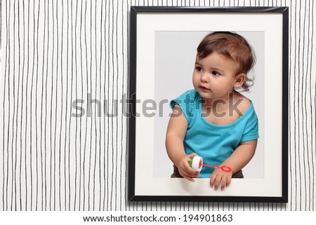 baby looking through a black frame