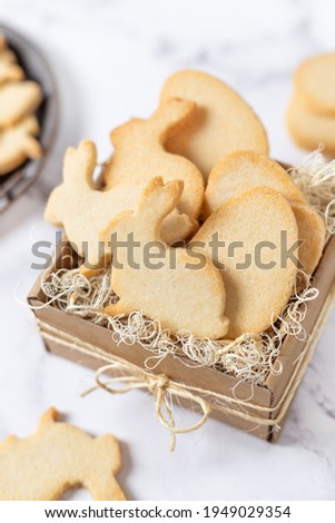 Easter cookies in cardboard gift box, egg and rabbit shaped plain almond biscuits close up