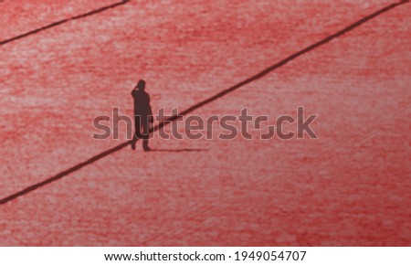 Defocused and blurred photo of Red Square, Moscow, man walking alone. Uncertain future red background concept. Royalty-Free Stock Photo #1949054707