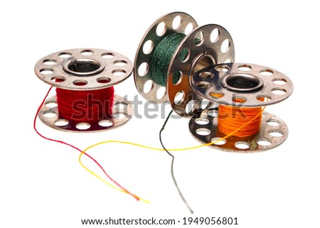 multicolored threads on bobbins from a sewing machine isolated on white background Royalty-Free Stock Photo #1949056801