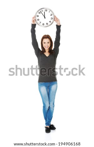 Happy young woman holding office clock