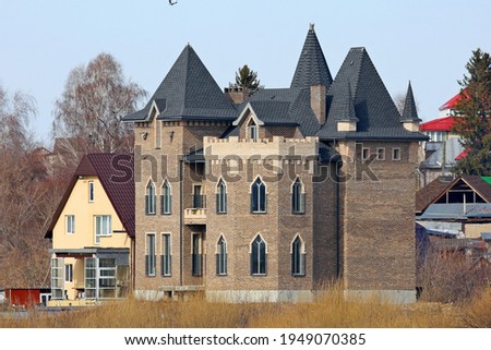 Picturesque house (castle) against the background of the forest and blue sky