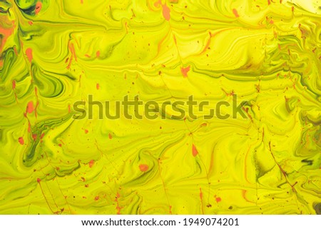 Watercolor stains. Watercolor natural background from stains similar to marble yellow and green paint with red splashes close-up. Sprayed liquid textured paint for wallpaper, cards and invitations.