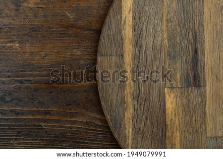 Cutting board or kitchen board on a wooden background. Space for text. Top view.
