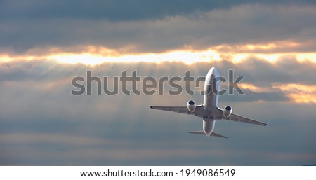 Airplane flying over tropical sea at sunset
