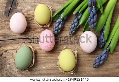 Violet hyacinth flowers and Easter eggs on wooden background. 