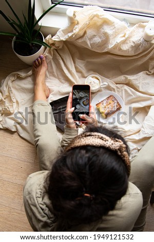  a woman takes photos of her breakfast with pudding on her phone