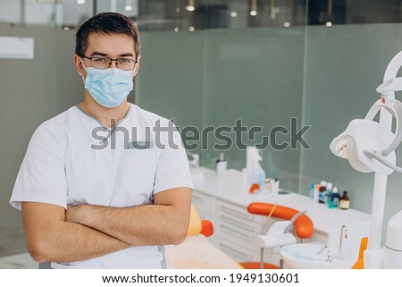 Dental doctor standing at clinic wearing mask