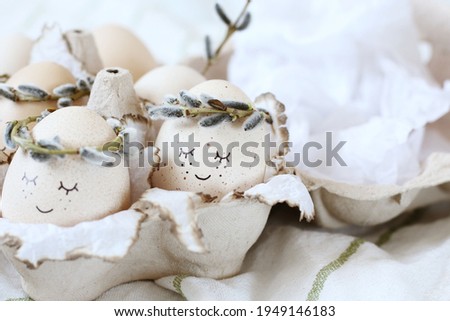 Eggs with face and wreath of willow in an eco-friendly paper box .Creative concept photography. Happy Easter.