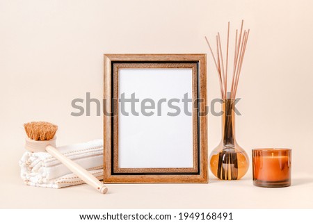 Golden picture frame mockup with candle, home fragrance and towel for bathroom art and design