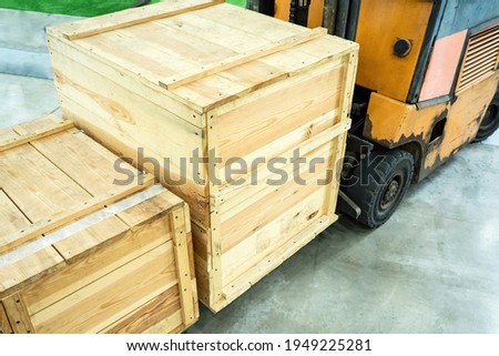Wooden crates on a loading machine. Concept - transport and loading machine. Loading and unloading equipment. Warehouse machines. Unloading wooden crates. Fragment of a forklift with wood crates.