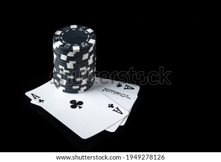 Poker cards with three of a kind or set combination. Close-up of playing cards and chips in poker club. Black background