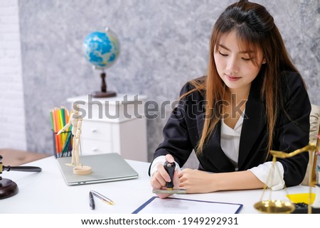 
Young Asian businesswoman stamp approval of documents at office.