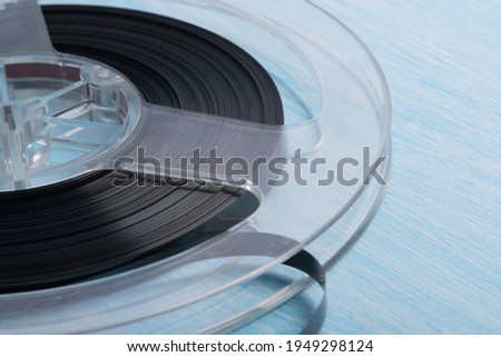 close-up of a reel with magnetic tape for recording music, retro version, on a blue background Royalty-Free Stock Photo #1949298124