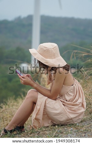 A young woman wears a pink dress and enjoys the beautiful nature, taking a restful air.