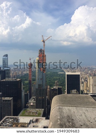 Aerial photo of two buildings during construction in front of the Central Park, Manhattan. Cranes on top of the building. New York City, United States.