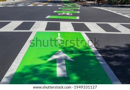 Bicycle path and pedestrian crossing, colorful road, markings on the asphalt, bright light green color.