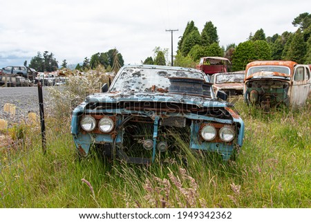 Antique cars on a big scrapyard at the end of Old Coach Road Trail, North Island of New Zealand Royalty-Free Stock Photo #1949342362