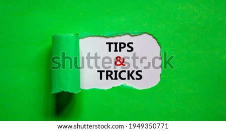 Tips and tricks symbol. Words 'Tips and tricks' appearing behind torn green paper. Beautiful green background. Business, Tips and tricks concept. Copy space.