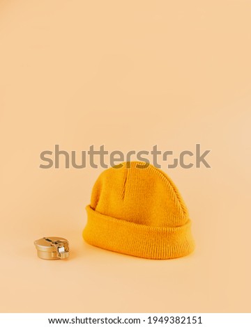 Travel concept, yellow hipster hat and compass on beige background.