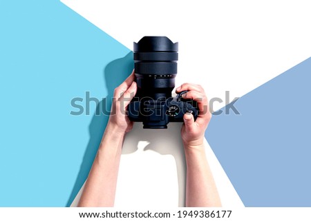 Person holding a SLR camera from above Royalty-Free Stock Photo #1949386177