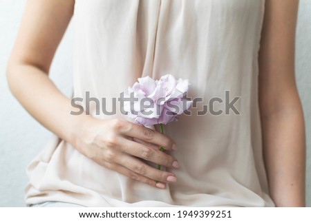 Woman holding elegant purple rose in her hand. Shallow focus