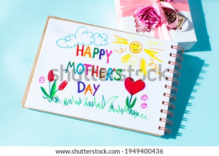 Mothers day card made craft child. Text Happy Mothers day. On a colored background. Gift and picture made by the kids for mom.