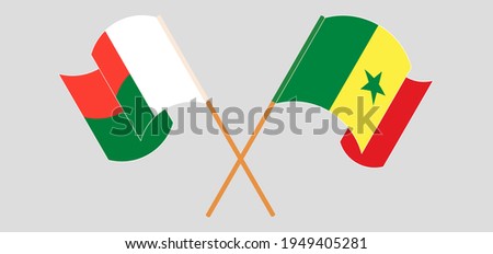 Crossed and waving flags of Madagascar and Senegal