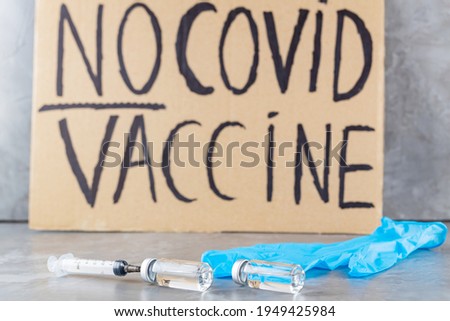 'No covid vaccine' protestive placard. Anti-vaccination poster, vaccine bottle and syringe. Concept covid-19 coronavirus vaccination protest