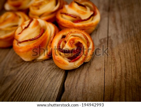Tasty homemade apple cakes over wooden background