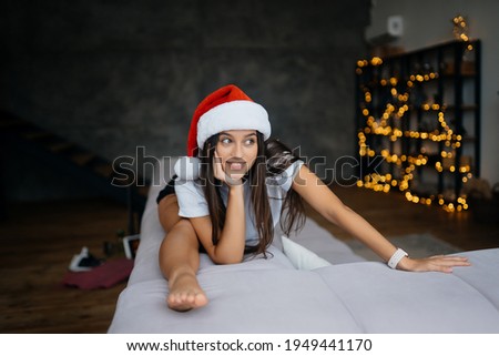Young woman in santa hat practicing sport gymnastic exercises