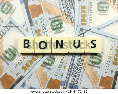 Business concept.Scrabble letters with text BONUS on banknote background.