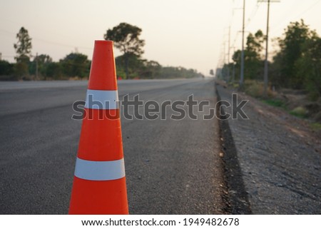 Red rubber cones are placed in the paved road. For safety on the road