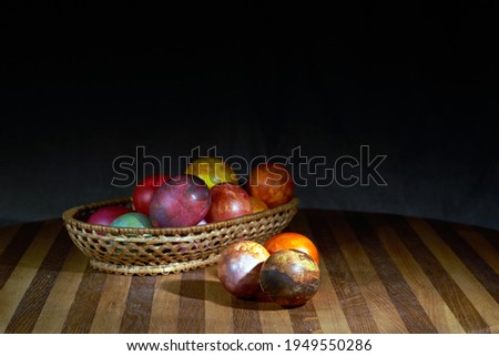 Traditional Easter Food.  Natural dyed Easter eggs in a basket on a table,  linen fabric background. Selective focus. Free space for text. A low key image.