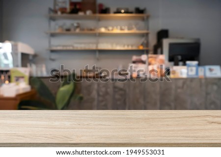 Wooden table with blur background of cafe and coffee shop.