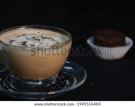 hot latte served in the glass on black background (Low-key Picture Style) ,hot coffee in a glass with cream poured over,hot drink  on a dark background
