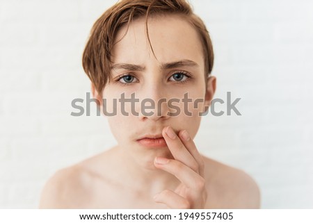 Teen boy looks at his first mustache, puberty period, early adulthood Royalty-Free Stock Photo #1949557405