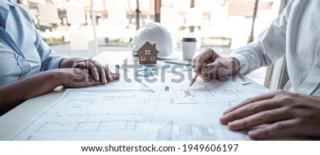 Team of architects or engineering consulting and analyzing working on objects tools and construction drawings inspection, discussing planning new architectural project on blueprint and model house.