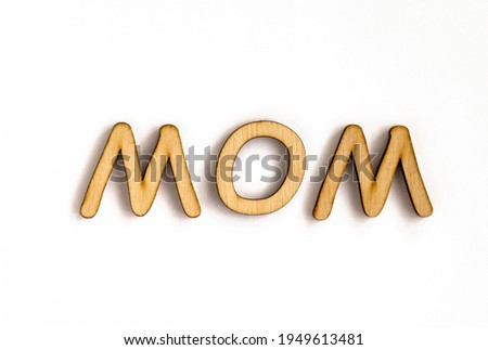the word "mom" from wooden letters isolated on white background, letters from natural materials for education, eco friendly logo or emblem