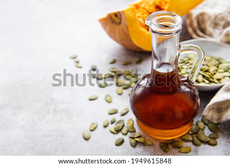 Bottle with pumpkin seed oil on gray concrete background