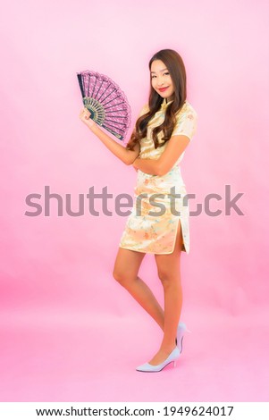 Portrait beautiful young asian woman with chinese new year concept and fan on color background