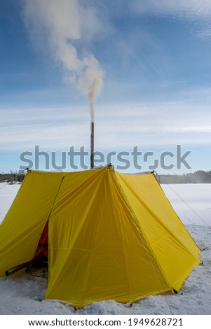 Camping sauna. Yellow tent with chimney  for sauna on winter forest lake  Sport lifestyle. Winter tourism.